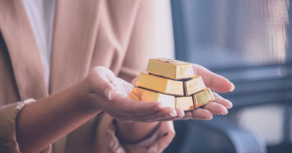A person holding gold bars in their hands, symbolizing wealth and prosperity