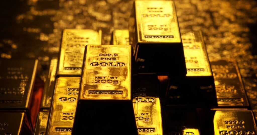 Gold bars stacked on a table, shining brightly