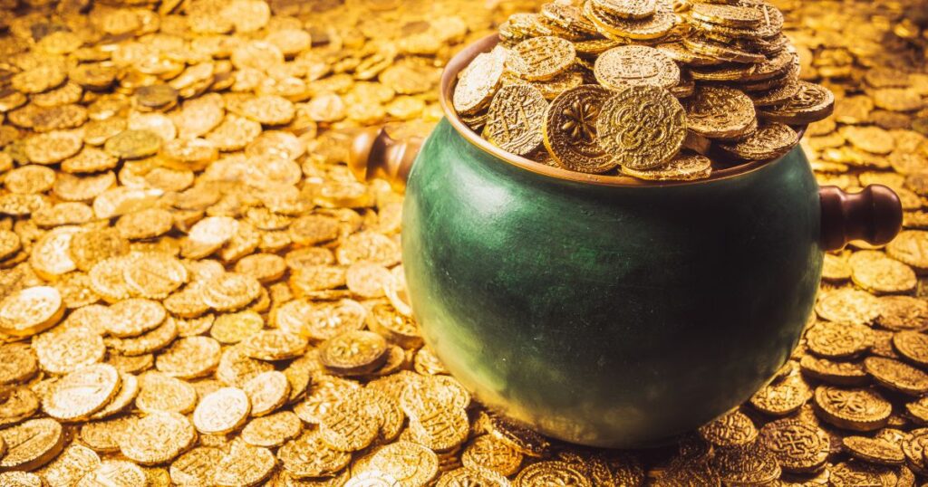 Gold coins in a pot on a shiny gold background
